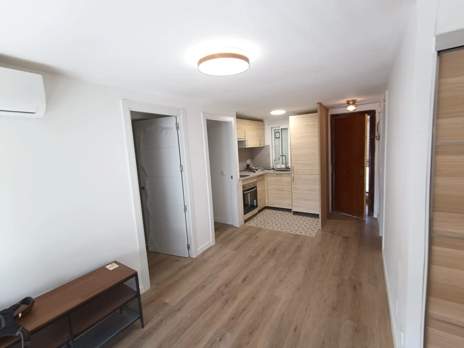 Salón y paso a la cocina de la vivienda reformada