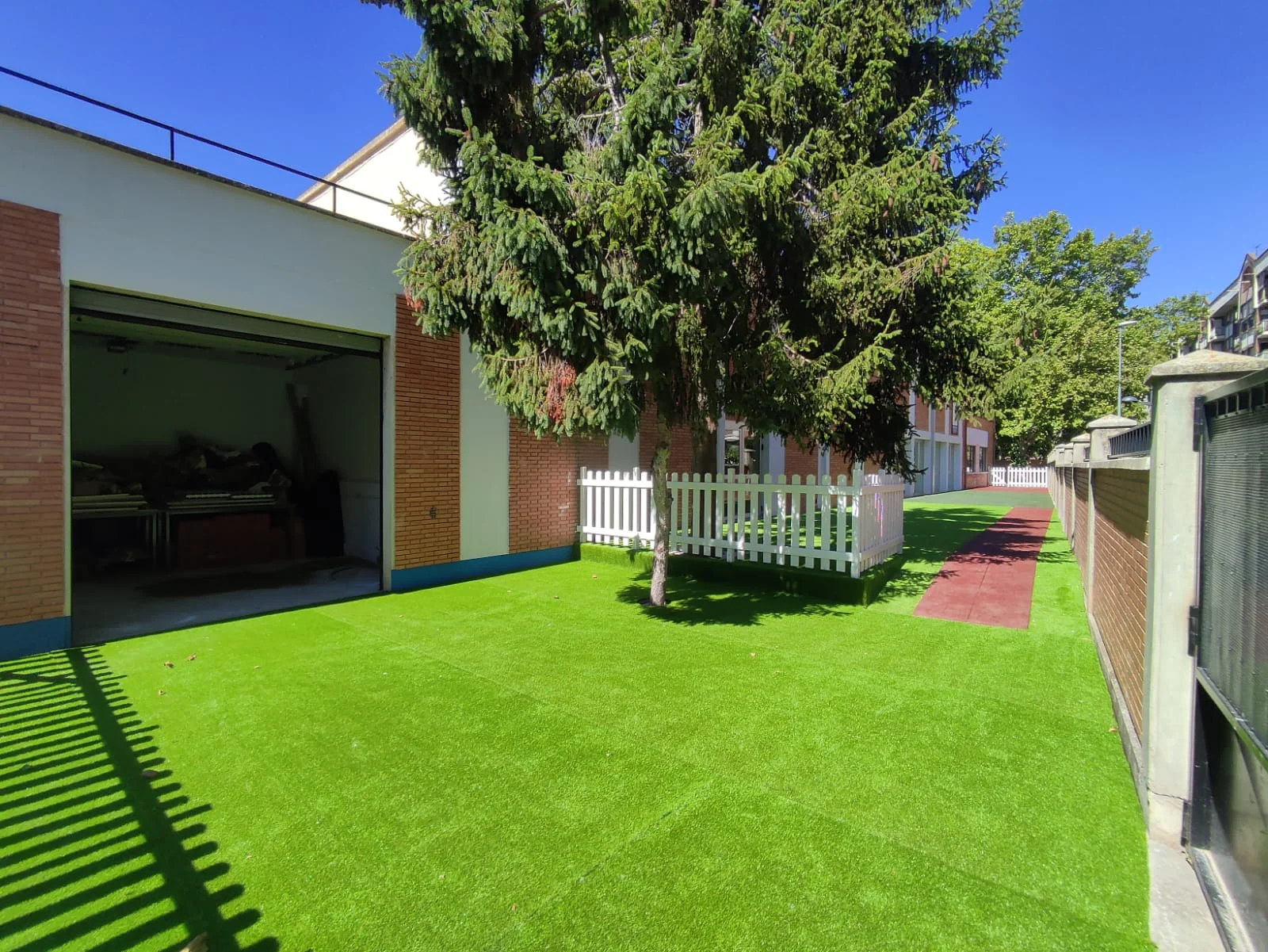 Patio del colegio terminado con césped artificial y vallado