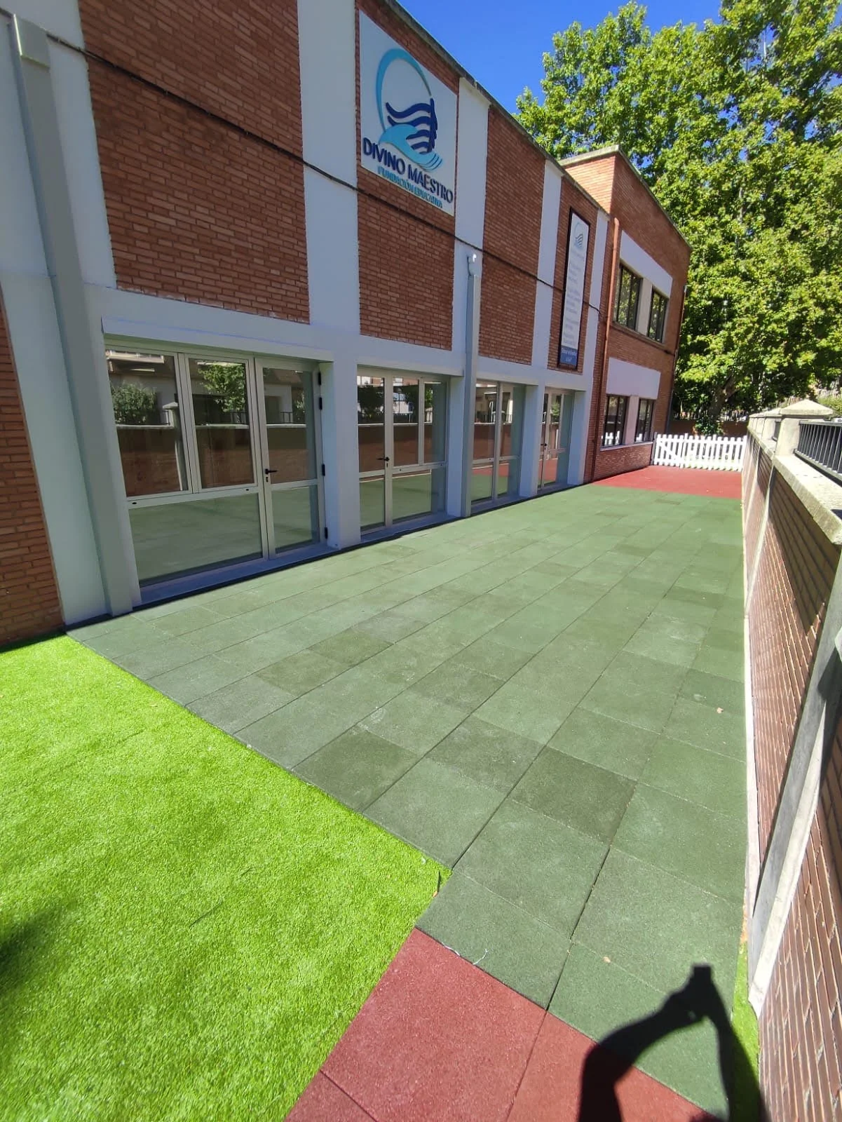 Patio terminado visto desde el aula, con solado y césped