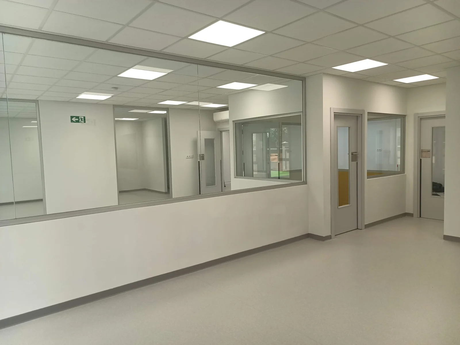 Aula amplia con ventanas interiores y luminarias empotradas