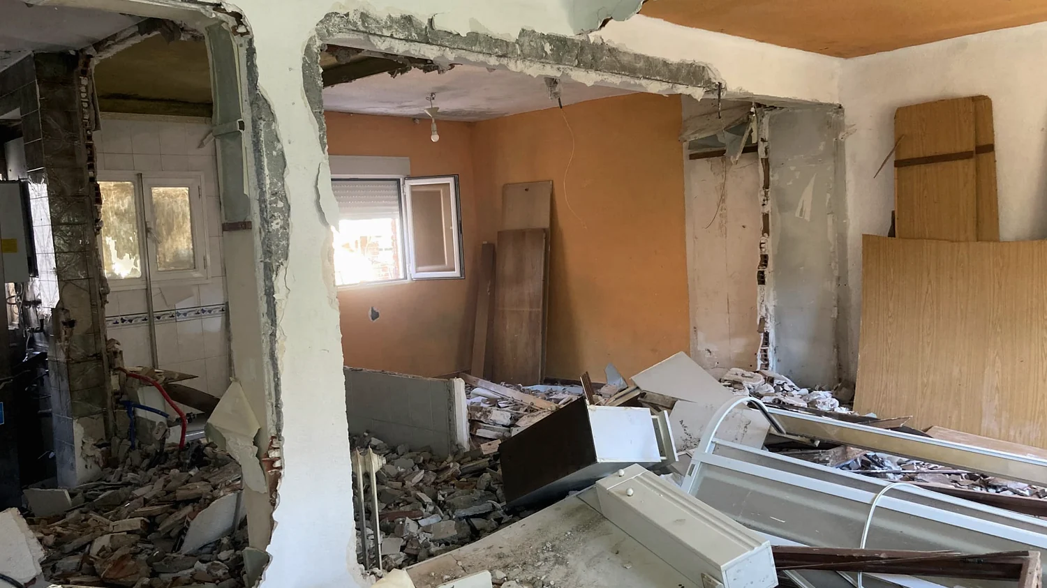 Vivienda en demolición, con el muro abierto y el escombro